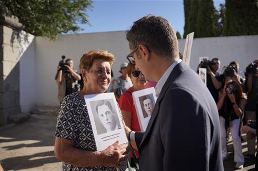 El ministro Félix Bolaños reconforta a la familiar de una víctima, que sostiene su foto
